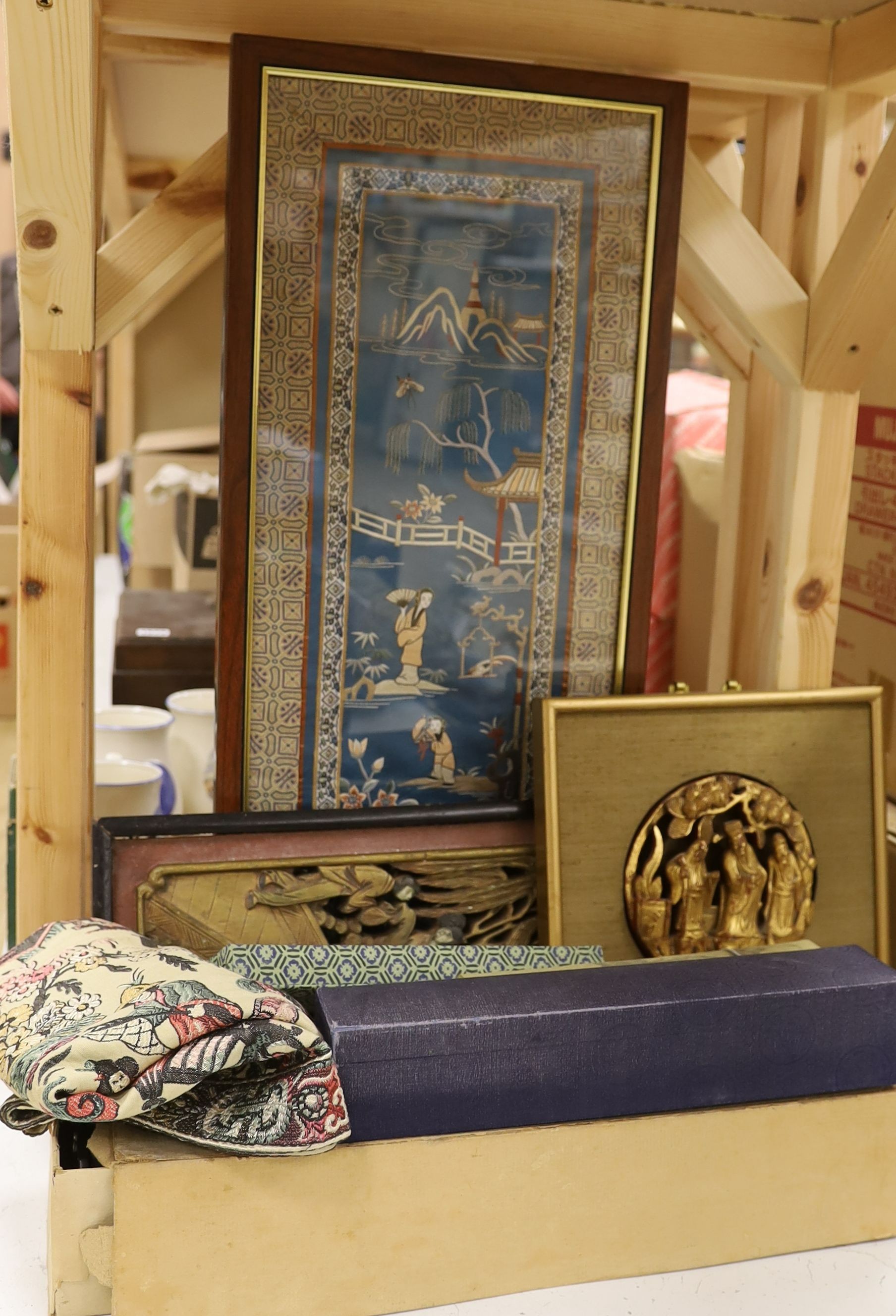 Two Chinese carved gilt wooden panels, a cased set of chopsticks, a boxed silk woven scroll and lacquer mahjong stands, a hand scroll and silk embroidery